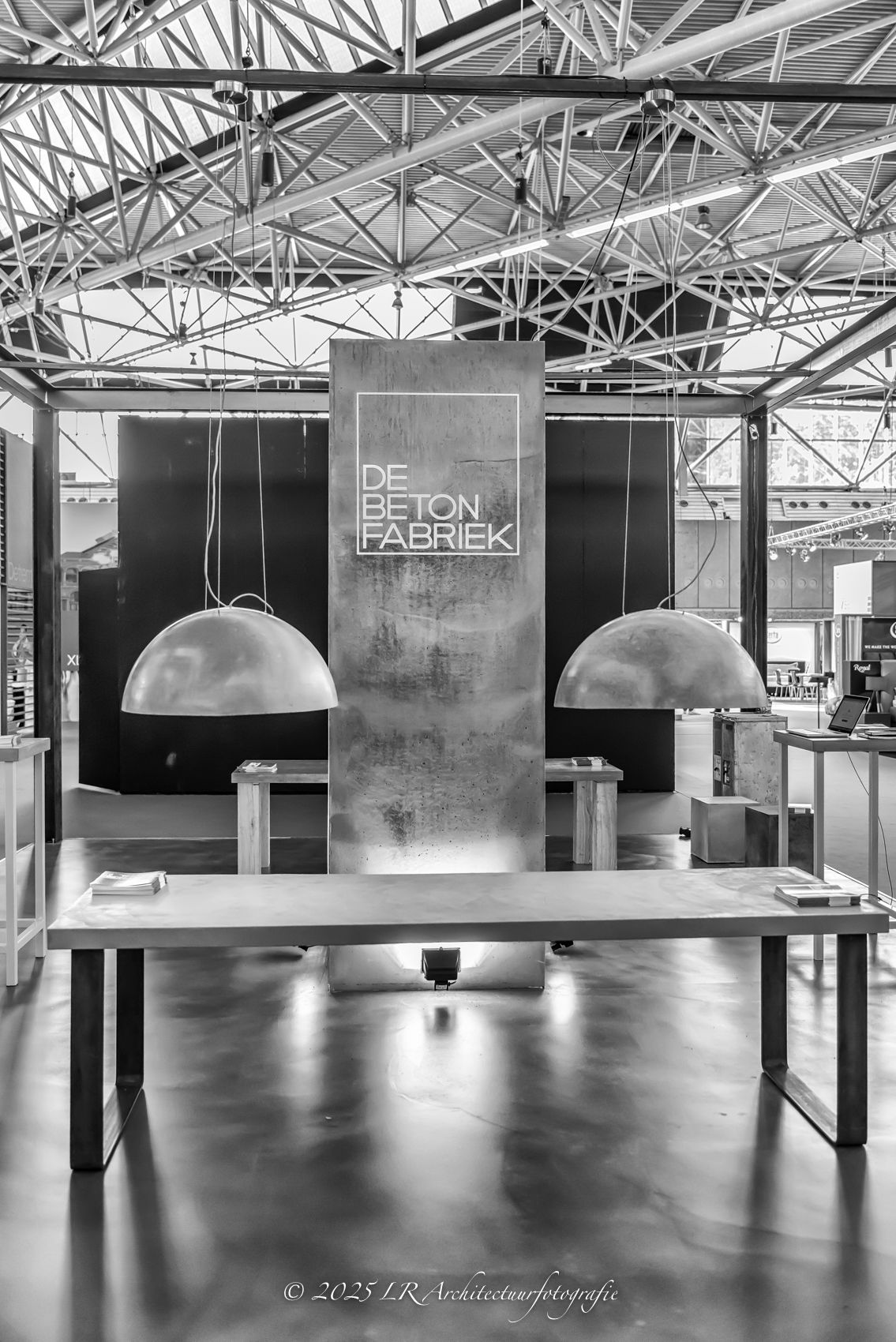 Een sfeervol horeca-interieur in zwart-wit, met een rij hangende bollampen boven een lange toonbank.