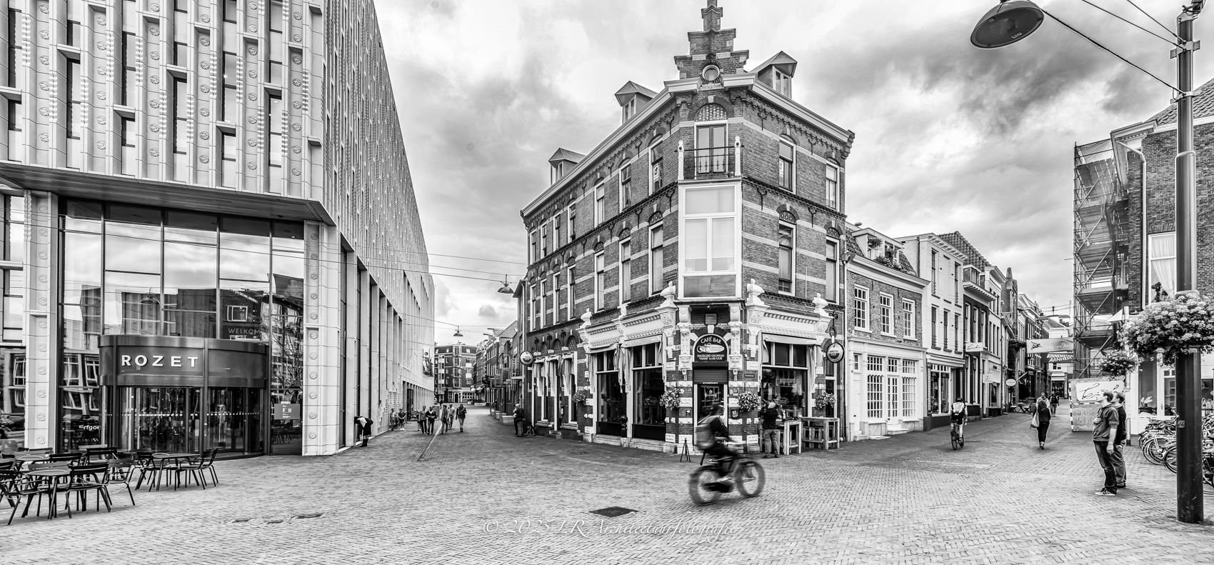 Straatgezicht in het centrum van Arnhem met cultuurgebouw Rozet naast een negentiende-eeuws hoekpand met trapgevel.