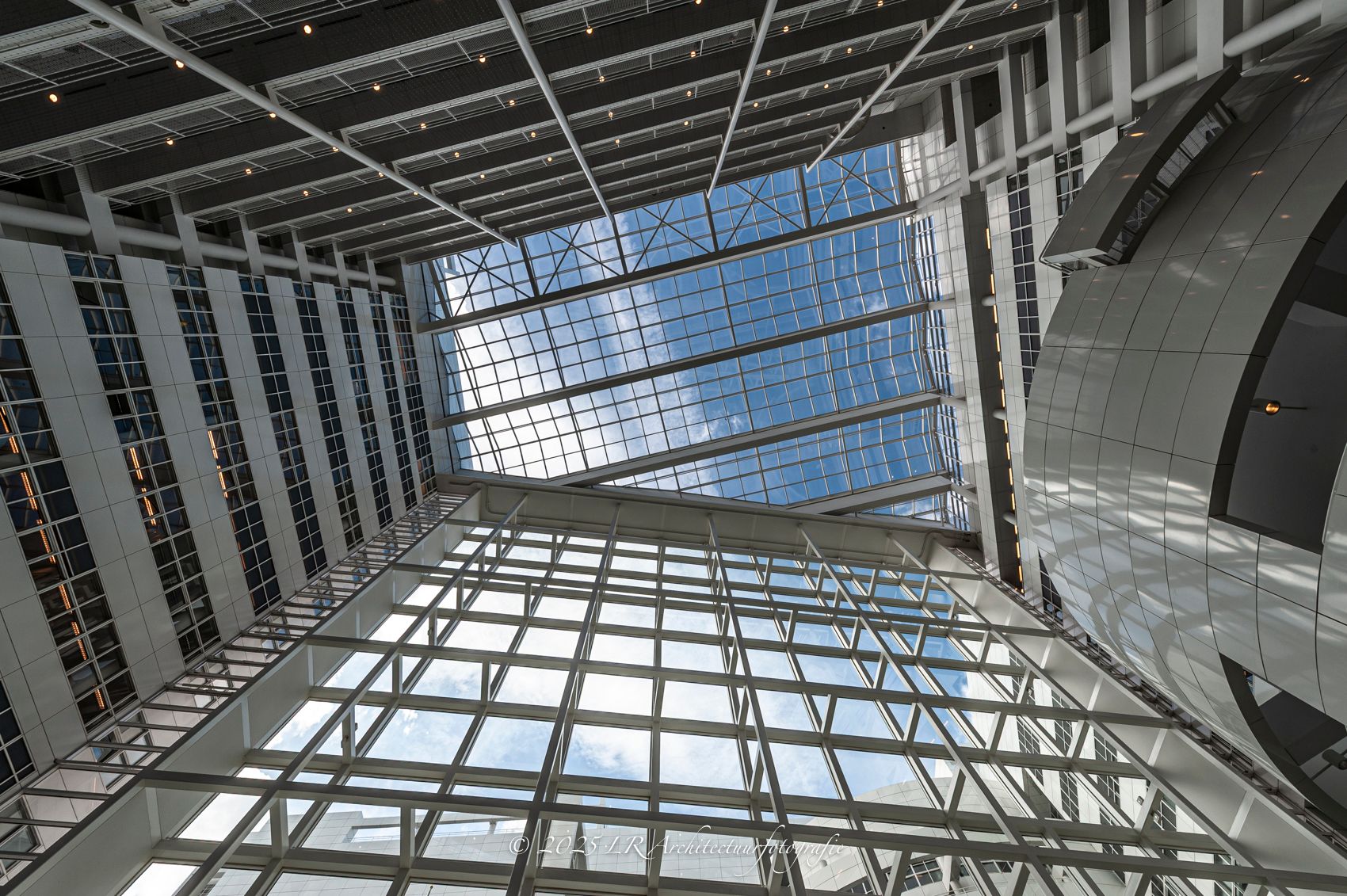 Een warme, gebogen ruimte waarin gefilterd licht langs vloeiende wanden valt.
