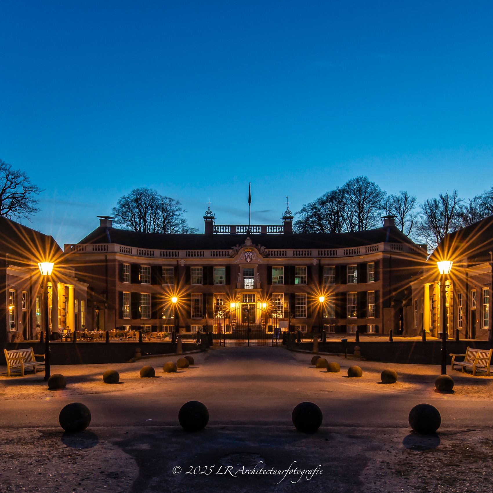 Een warm verlicht gebouw in de avond, vierkant gekaderd.
