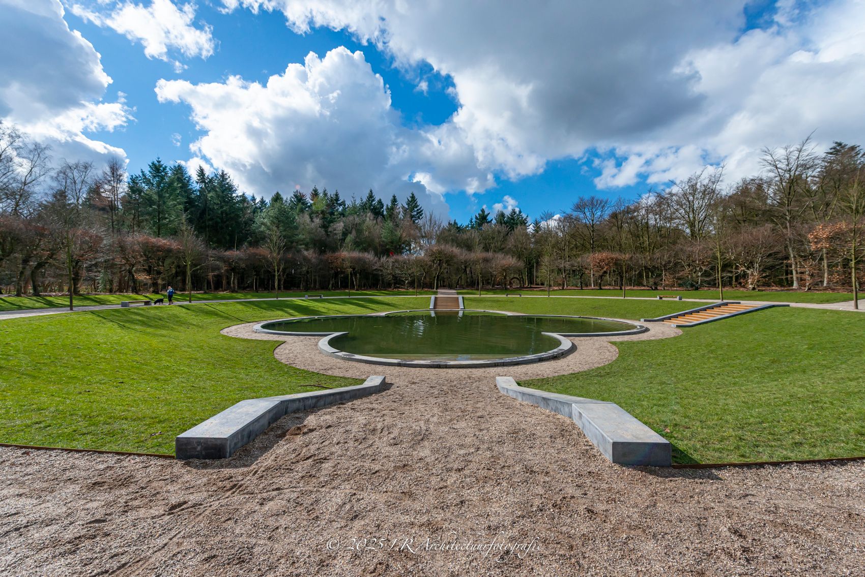 Een lindelaan met een pad door het Baarnsche Bos op een heldere dag.
