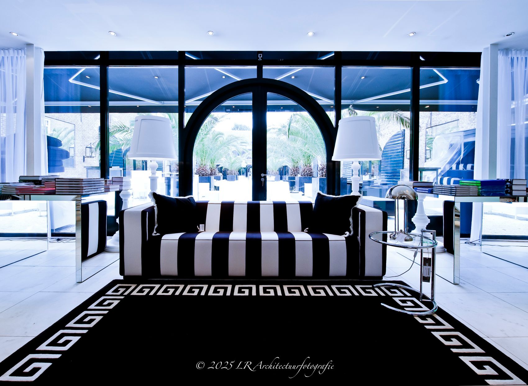 Een monumentale zaal met hoge boogramen en kroonluchters.