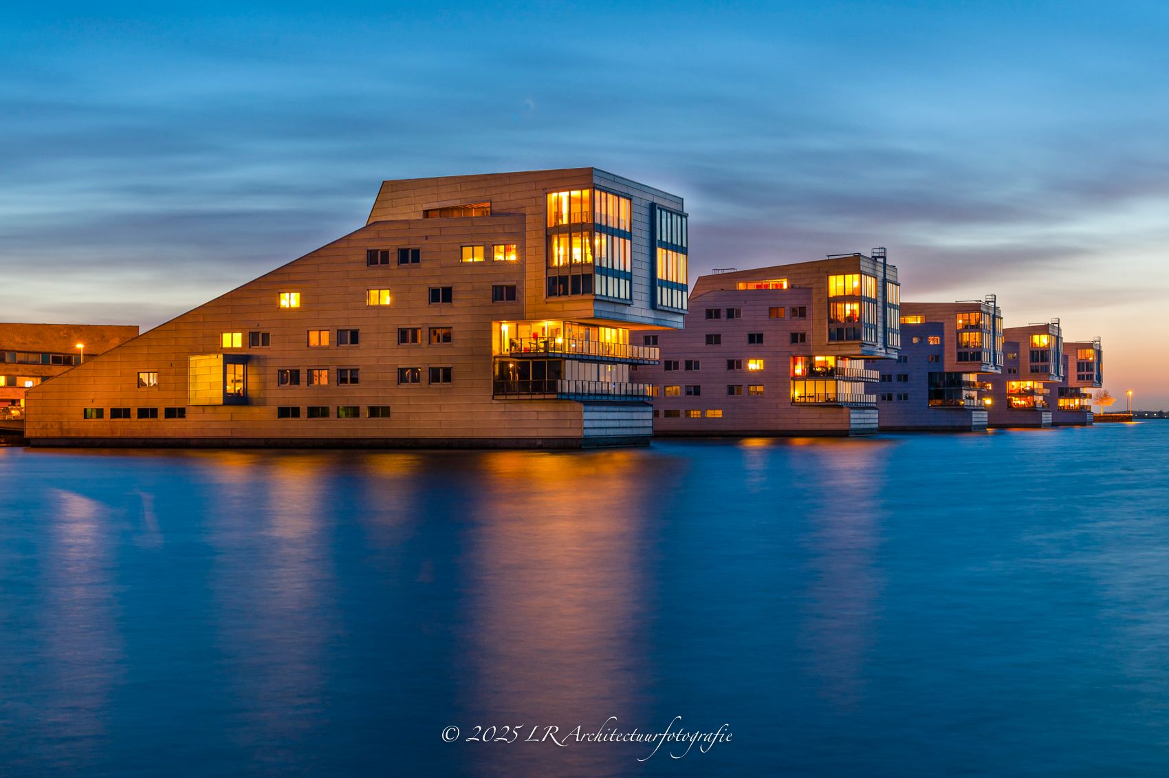 Een kleurrijke skyline in de schemering, weerspiegeld in het water.
