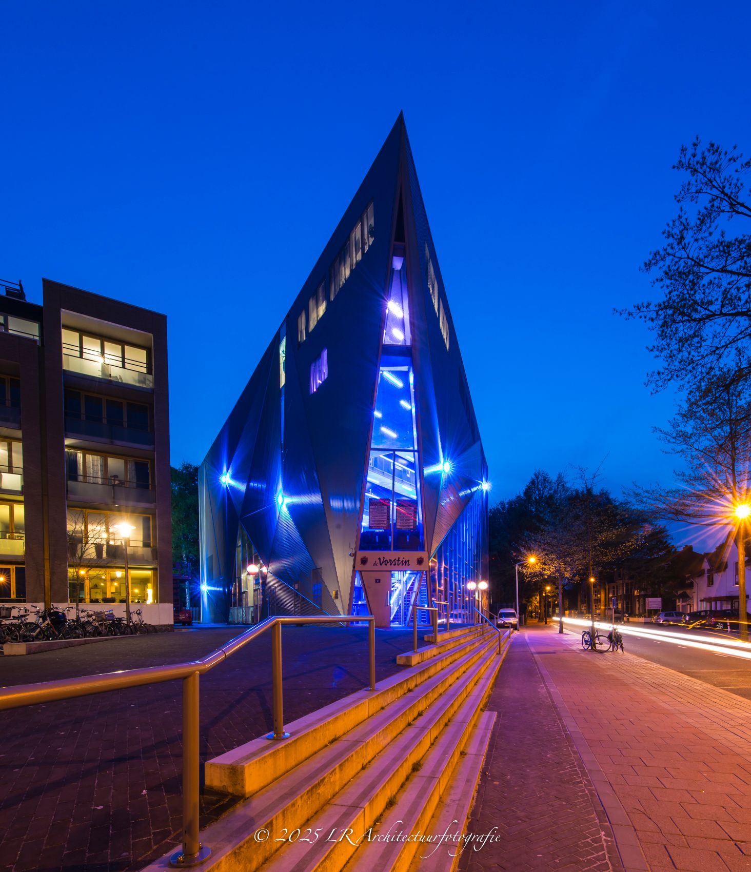 Een stadsstraat in de schemering met warme straatverlichting.