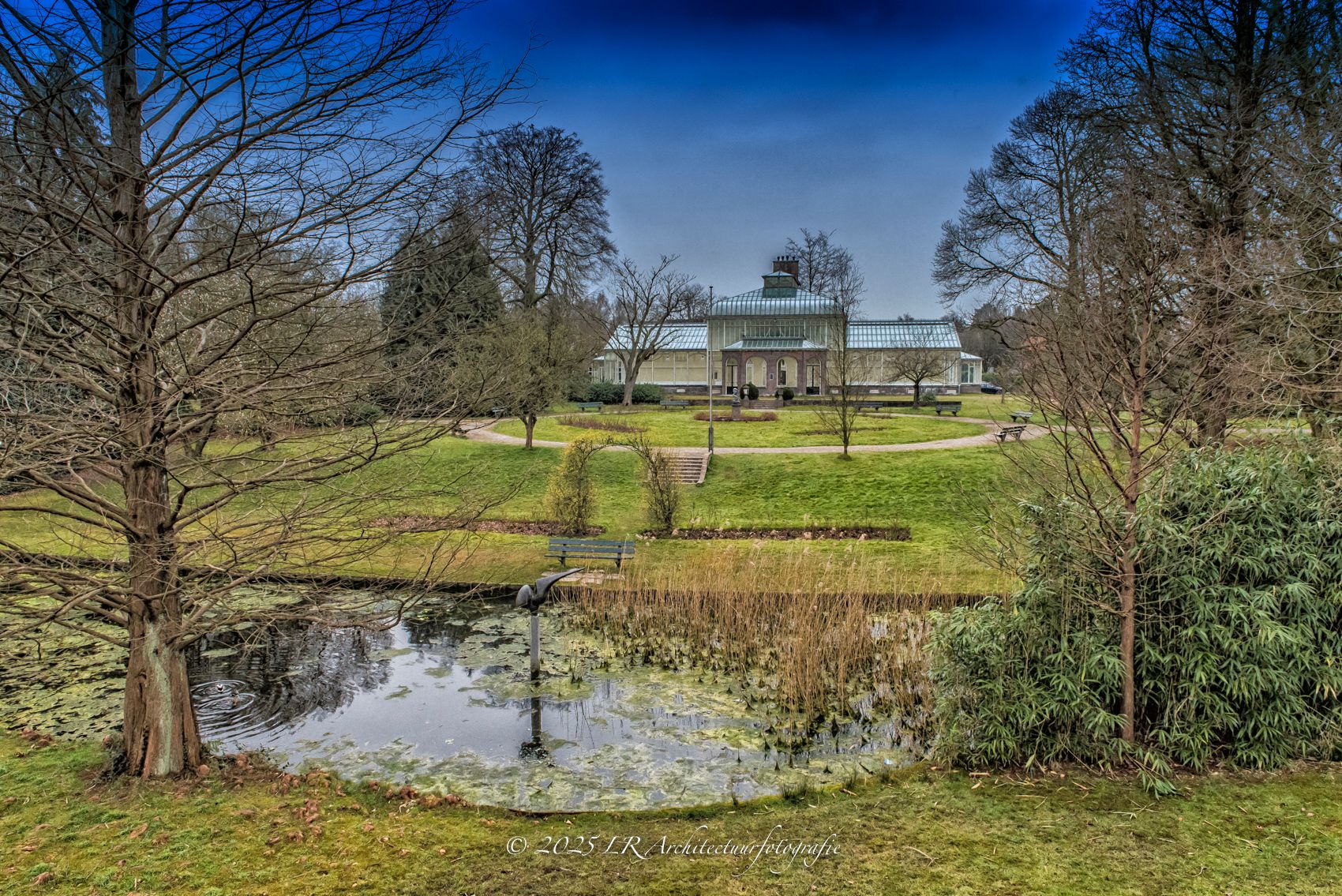 De wintertuin van het Cantonspark in Baarn, met glas en groen in daglicht.