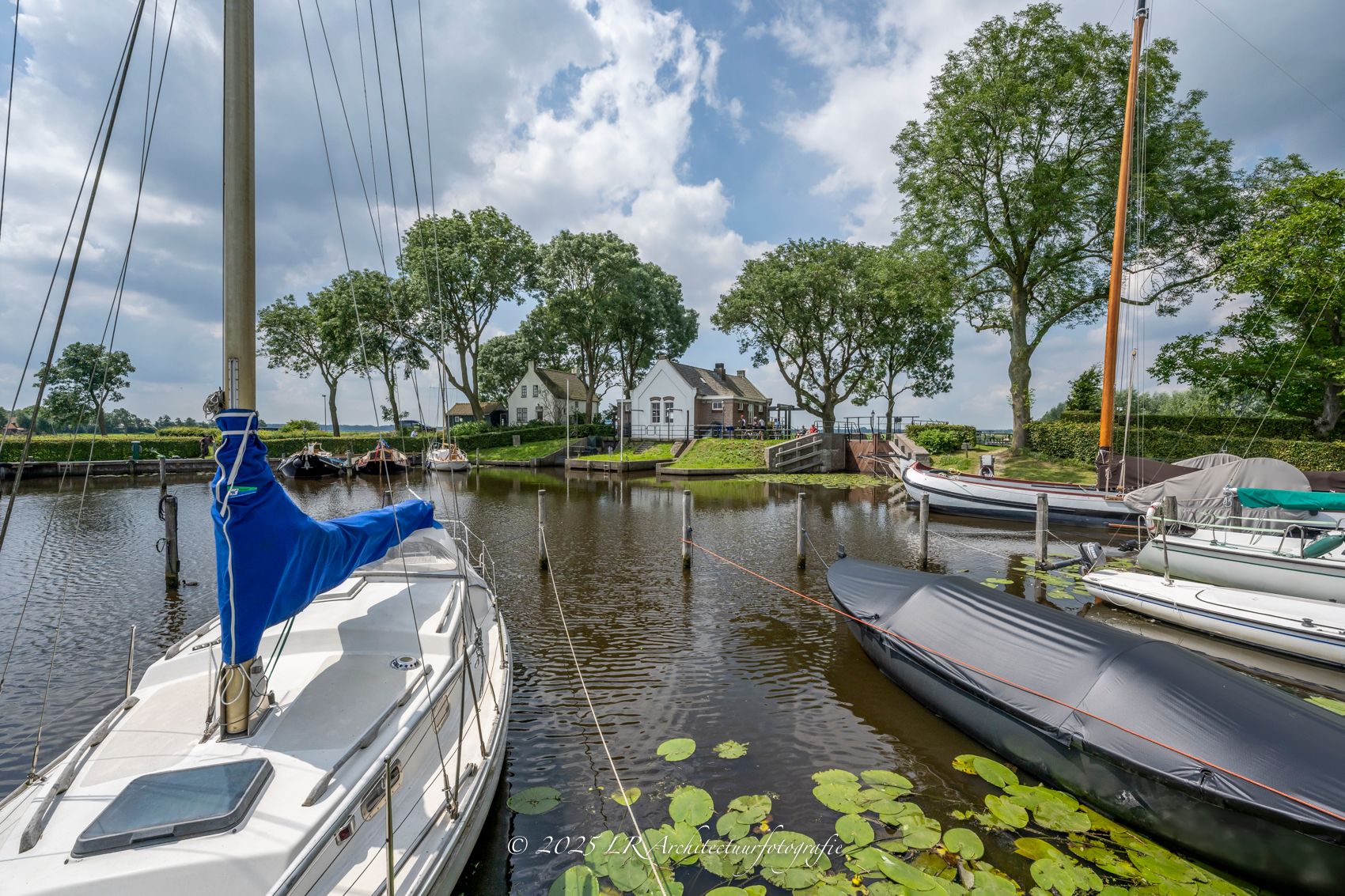 Een witte zeilboot in een jachthaven op een heldere dag.
